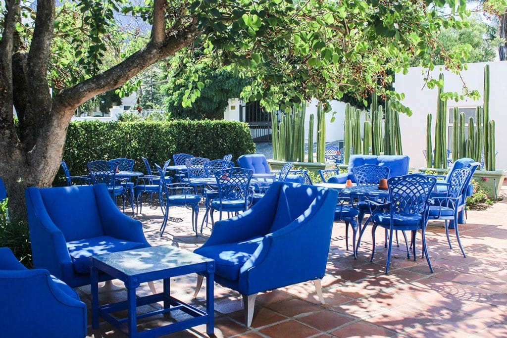 Blue chairs and tables on the terrace of Majeka House in Stellenbosch