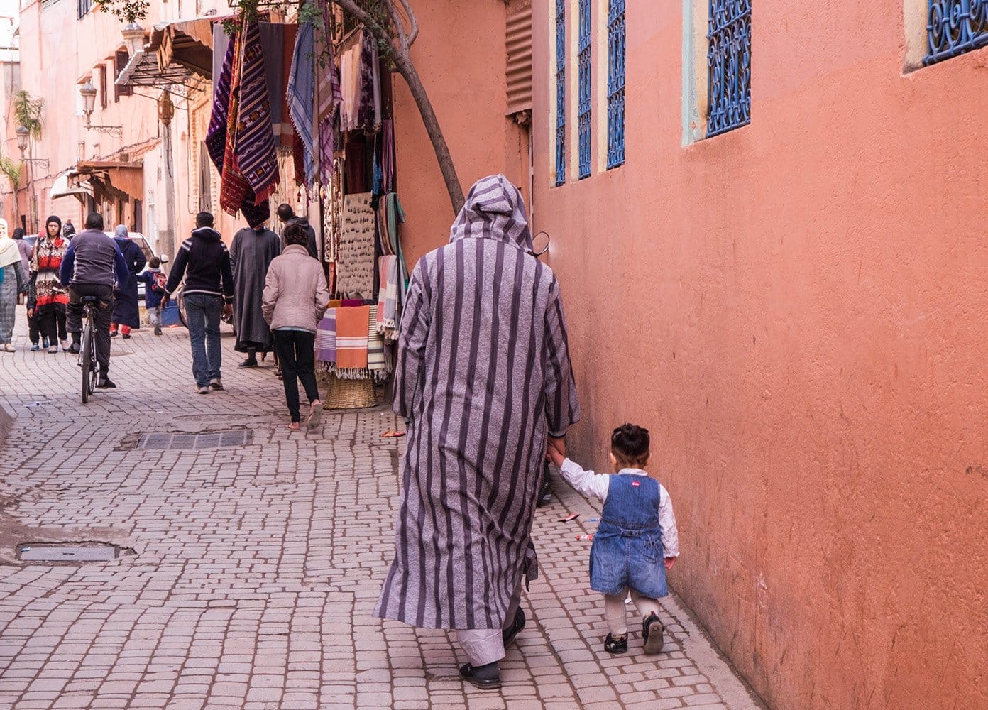 Man in a striped cloak walking with a little boy in Marrakech