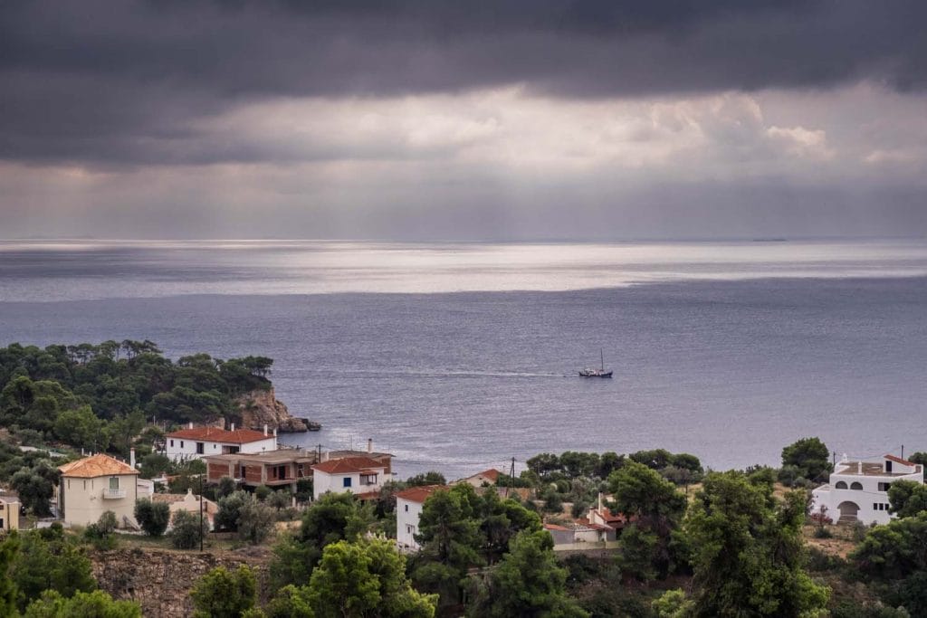 Stormy sky over the ocean in Alonissos, lone boat in the harbor