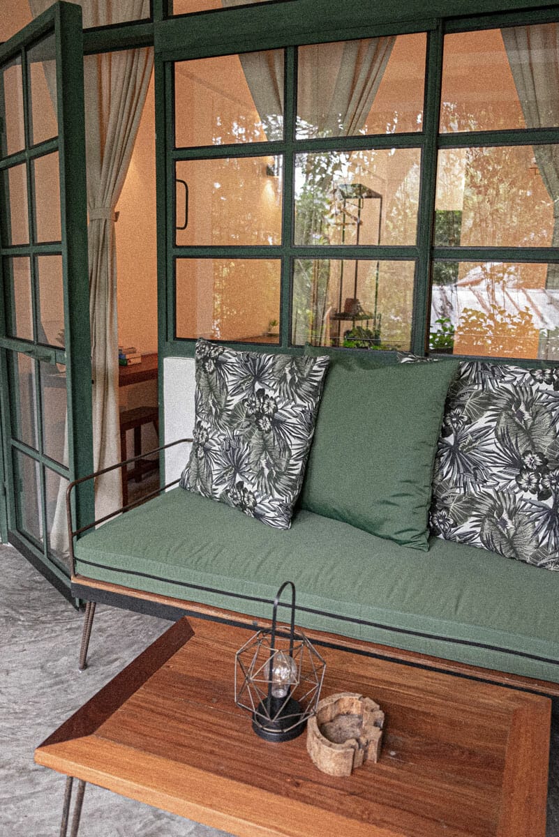 Green couch and wooden table on a balcony
