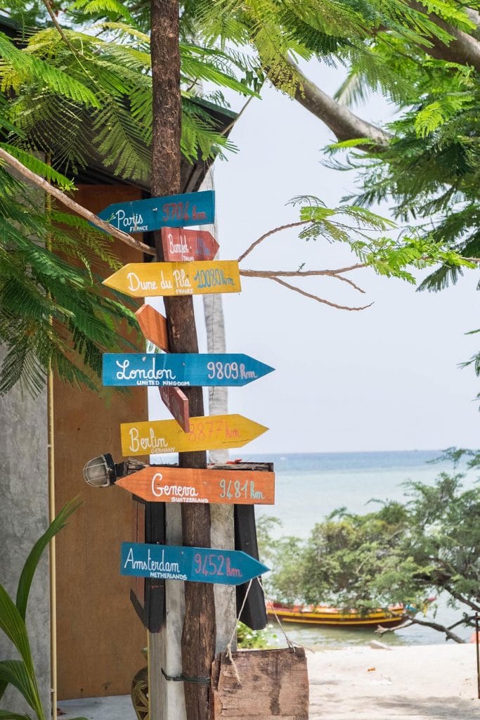 Sign with various cities and their distance to Koh Tao