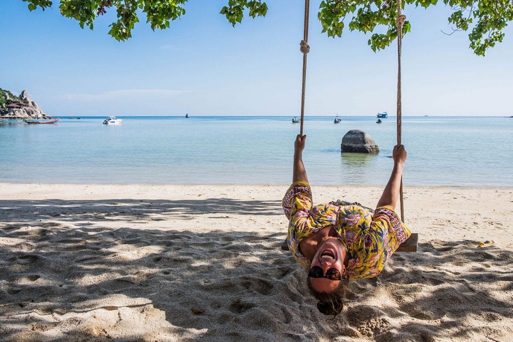 Annika Ziehen laughing on a swing on the beach in Koh Tao