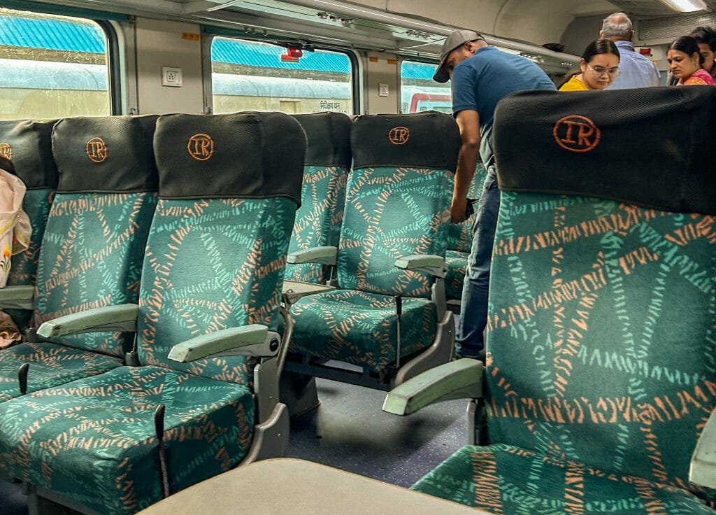 chair on an Indian train with turquoise chairs