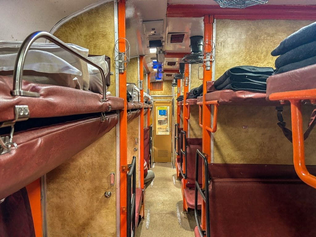 AC3 compartment on a train in India with red bunk beds